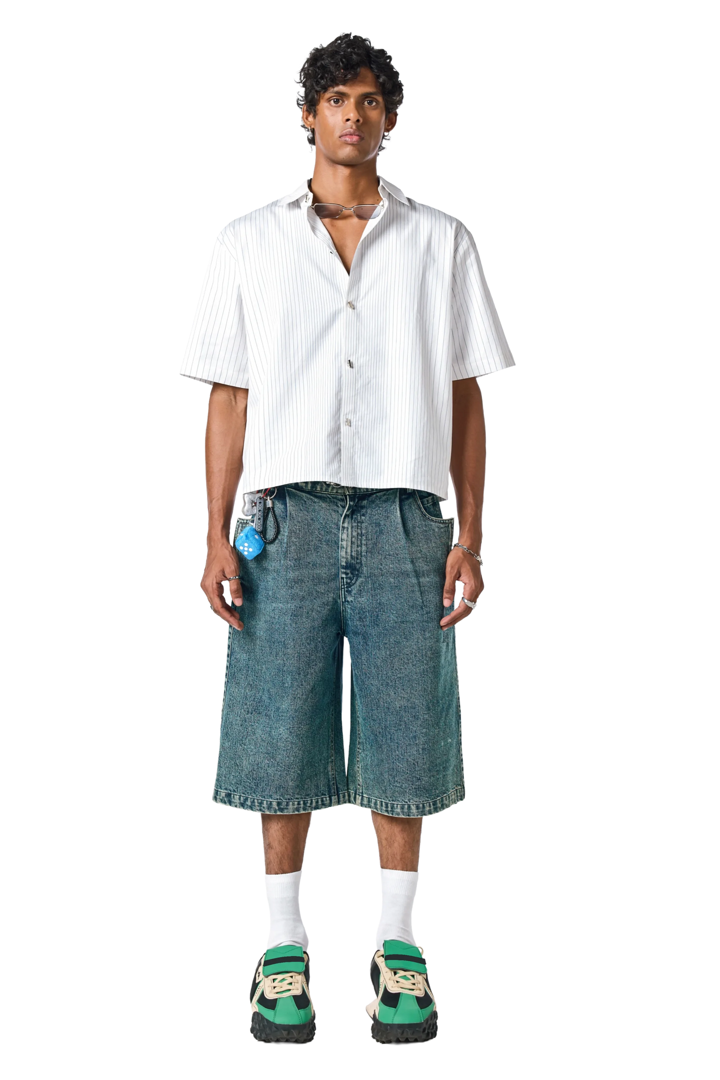 Man wearing a white shirt and denim shorts on a white background