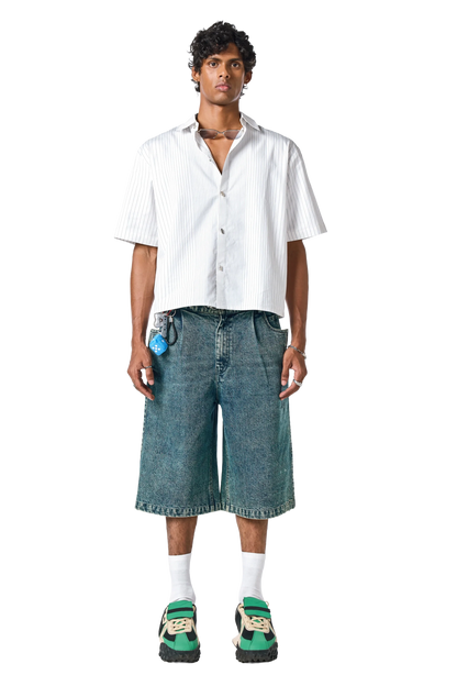 Man wearing a white shirt and denim shorts on a white background
