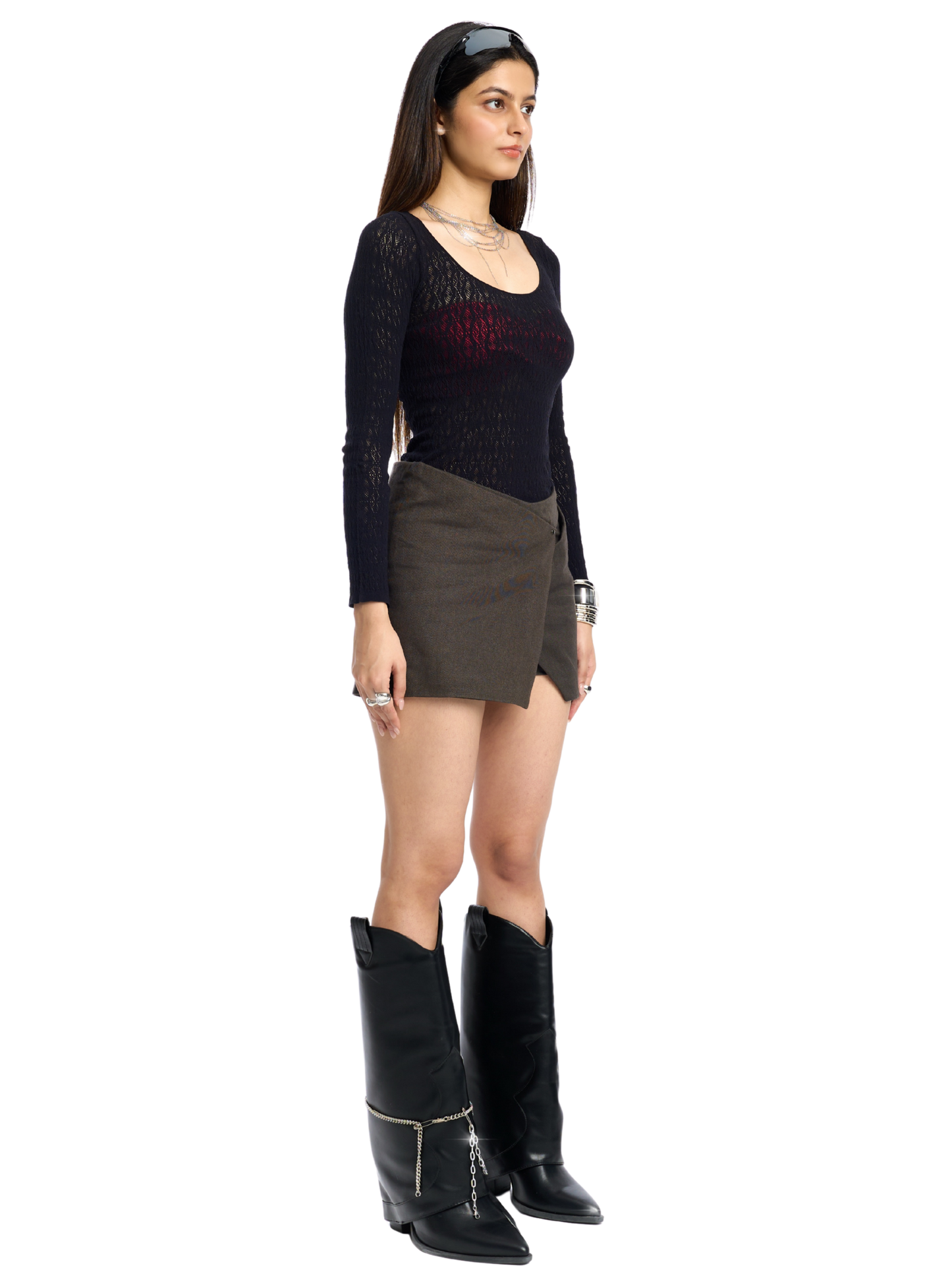 Woman wearing a black top, brown skirt, and black boots on a white background