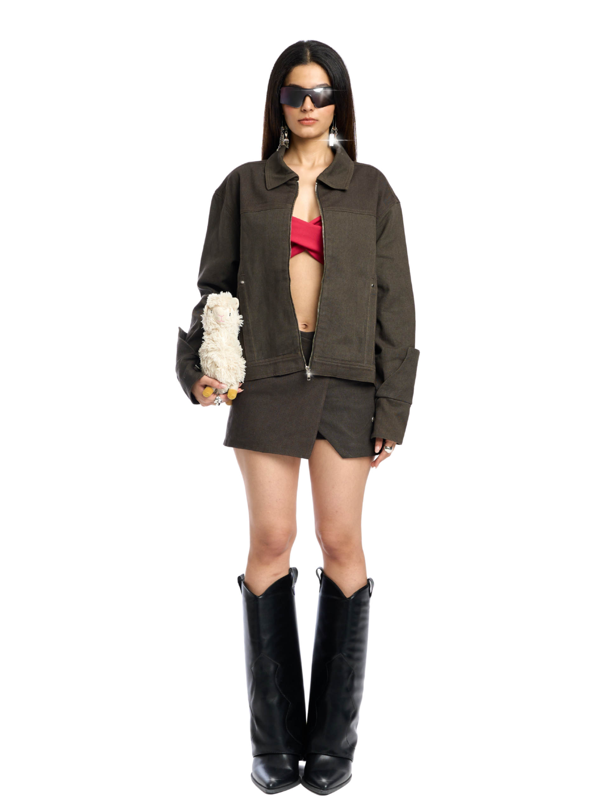 Woman wearing a green jacket, red top, and black boots on a white background